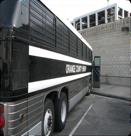 Orange County Sheriff inmate transportation bus parked beside a secure facility