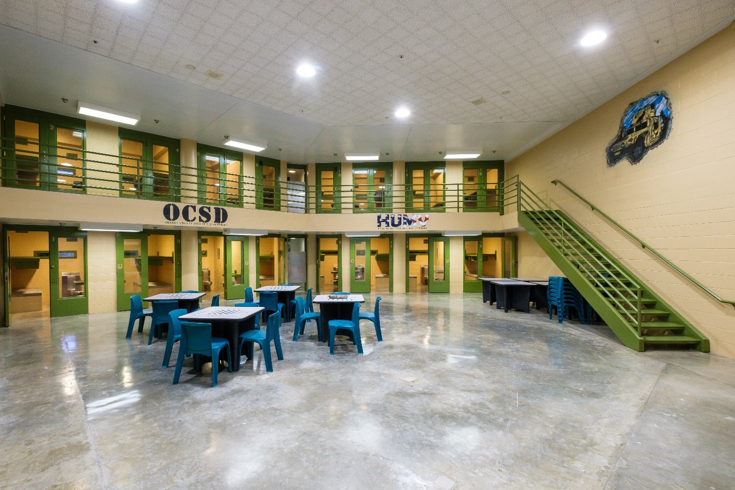Tables, cells and military service murals inside the veterans housing unit at Theo Lacy